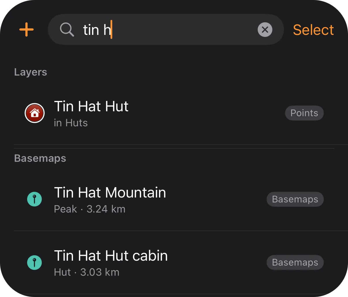 Search in the Layers tab on iPhone with tin h typed: a Layers section listing Tin Hat Hut, then a Basemaps section listing Tin Hat Mountain and Tin Hat Hut cabin with their distances