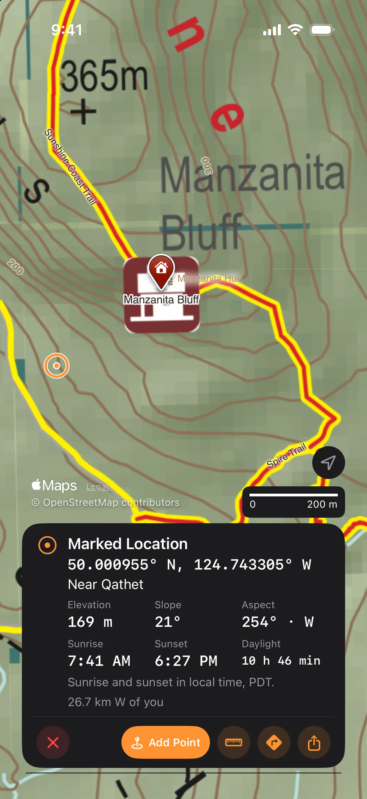 The place card on iPhone after holding a spot on the bluff: the ring and dot on the map, and the card reading Marked Location with the coordinate, Near Qathet, Elevation, Slope and Aspect, Sunrise, Sunset and Daylight, the distance from you, and Add Point