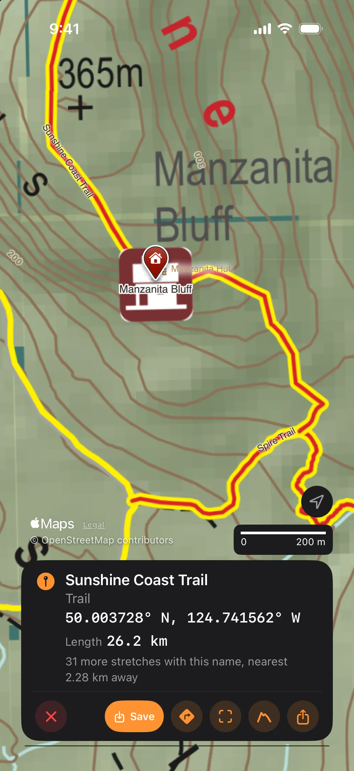 A basemap trail tapped on iPhone beside Manzanita Bluff: the card at the foot of the screen with its name, Sunshine Coast Trail, the line Trail, the coordinate, Length 26.2 km, the count of other stretches with this name, and Save